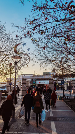Izmir, Turkey, 4th of January 2022 - People walking on the street surrounded by trees and decorationsの写真素材