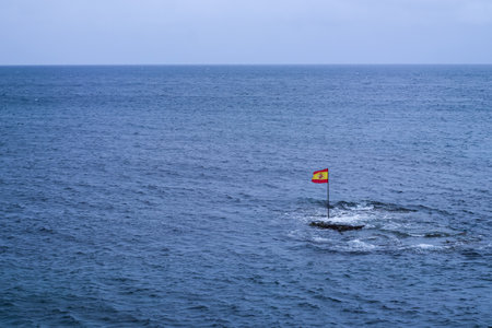 Spanish flag standing in the middle of the Atlantic Ocean, Gran Canariaの写真素材