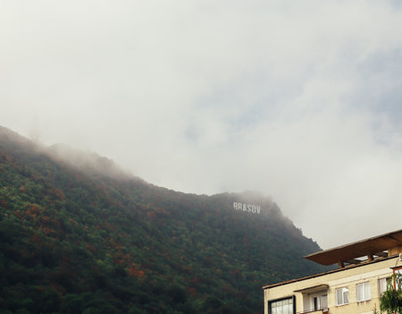 Close up of Brasov sign on mountain and buildings with copy space