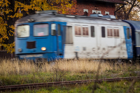 Transportation train going at high speed with autumn trees and railwayの写真素材