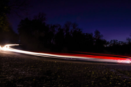 Night light painting with cars going in a curved roadの写真素材