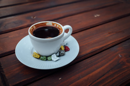 Close up of turkish coffee in a small white cup with colourful stones around and copy spaceの写真素材