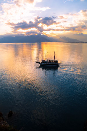Landscape of boat - yacht in the Mediterranean sea with mountains in the distance during the sunset, Antalya, Turkeyの写真素材