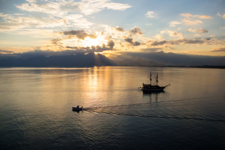 Landscape of boat - yacht in the Mediterranean sea with mountains in the distance during the sunset, Antalya, Turkeyの写真素材