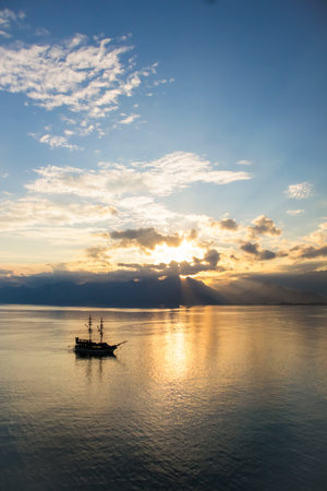 Landscape of boat - yacht in the Mediterranean sea with mountains in the distance during the sunset, Antalya, Turkeyの写真素材