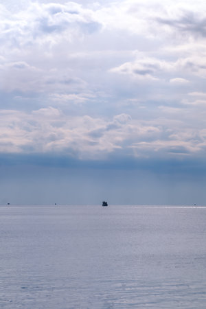 Boat in the middle of the Meditarranean sea during a cloudy dayの写真素材