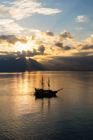 Landscape of boat - yacht in the Mediterranean sea with mountains in the distance during the sunset, Antalya, Turkeyの写真素材