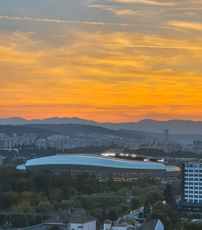 Sunset over the Cluj-Napoca city, Romania, with mountains in the distance. Cluj Arena Stadium during the sunsetの写真素材