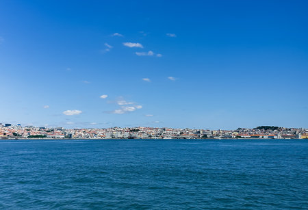 A panoramic view of Lisbon, Portugal, with its colorful buildings and waterfront under a clear blue skyの写真素材
