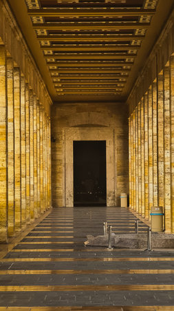 Symmetrical view of a grand stone colonnade hallway leading to a dark entrance at Anitkabir, Ankara, Turkeyの写真素材