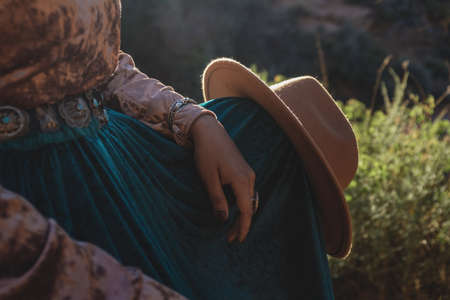 Native American woman with hat on knee in desert of Arizonaの写真素材