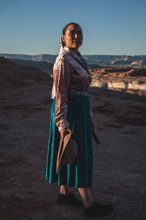 Native American Woman in Traditional Dress in front of Lake Powell Looking At Cameraの写真素材