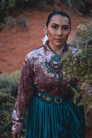 Navajo woman standing behind sage brushの写真素材