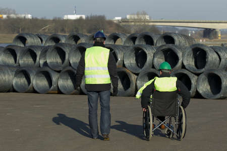 Rear view of male colleagues looking at cable wire construction siteの写真素材
