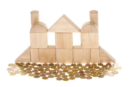A wooden structure surrounded with coins isolated on white backgroundの写真素材