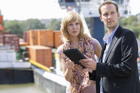 Colleagues with digital tablet looking awayの写真素材