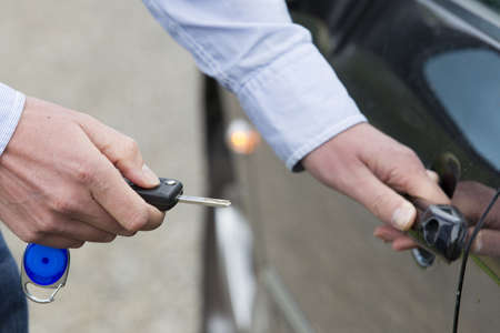 Cropped view of man with key unlocking car door  Horizontal shot の写真素材