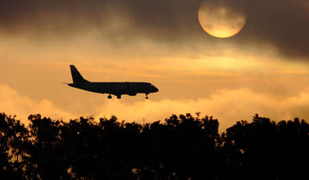 Silhouette of the big plane on a sunrise backgroundの写真素材