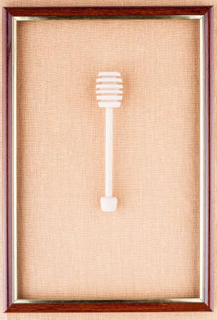 Honey dipper in the center of the frame on a linen backgroundの写真素材