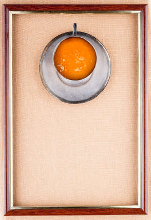 Honey in an iron cup and saucer in the frame on a linen backgroundの写真素材