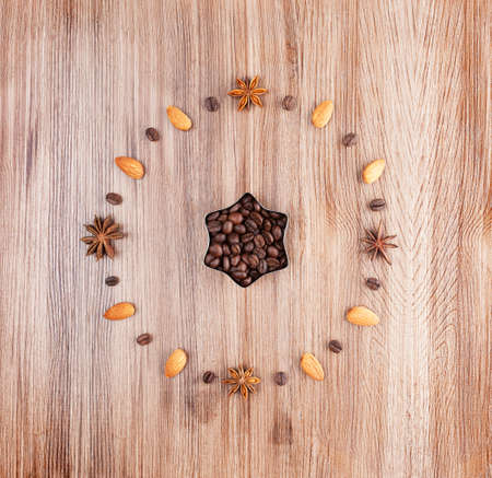 Clock face on a wooden background of almonds and coffee beansの写真素材