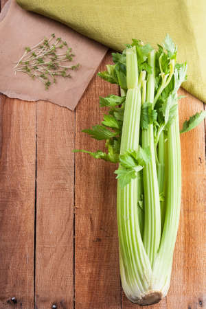Bunch celery and salad crees on the on light wooden background