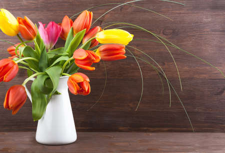 Bouquet of colorful tulips on dark wooden backgroundの写真素材