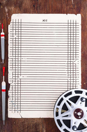 Sheet to record the results of fishing floats and reel surroundedの写真素材