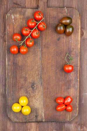 Set of different varieties of cherry tomatoes on a dark wooden backgroundの写真素材