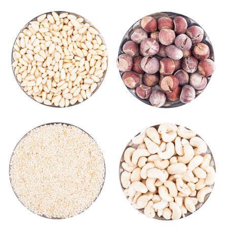 Assorted nuts on a flat plate, isolated on whiteの写真素材