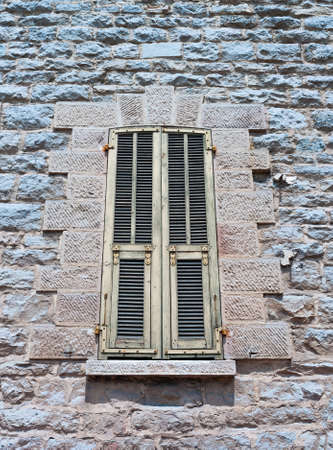 Typical old Mediterranean window with closed shuttersの写真素材