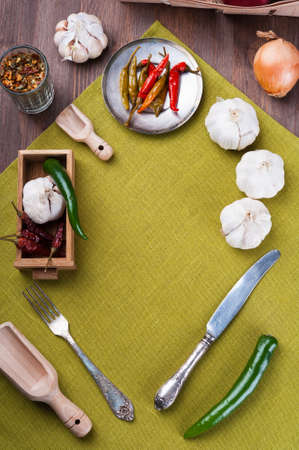 Several kinds of pepper and garlic, on green linen napkinの写真素材