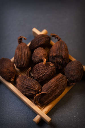 Chinese black cardamom on a black background