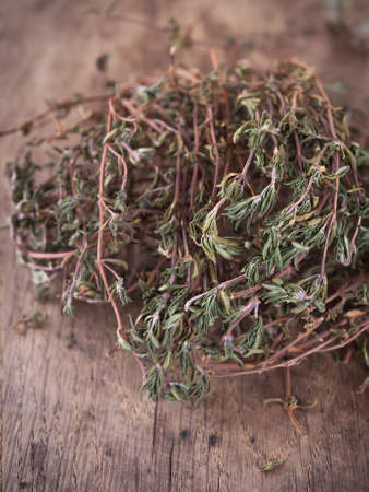 Dried thyme leaves and stems on a wooden deskの写真素材