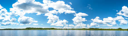 Panorama of the northern lake with blue sky and cloudsの写真素材