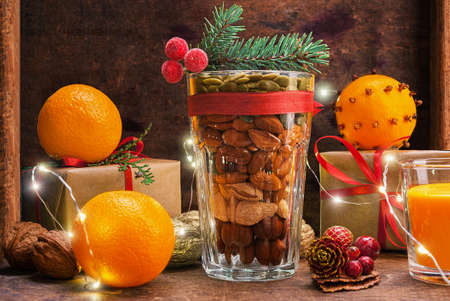 Christmas decoration glass with a variety of nuts on a wooden backgroundの写真素材