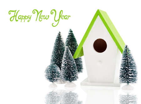 Christmas composition with bird house surrounded by fir trees isolatedの写真素材