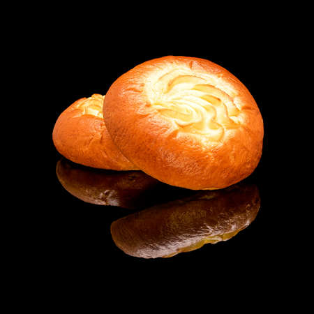 Yeast baked with cottage cheese. On a black glossy background with real reflection.