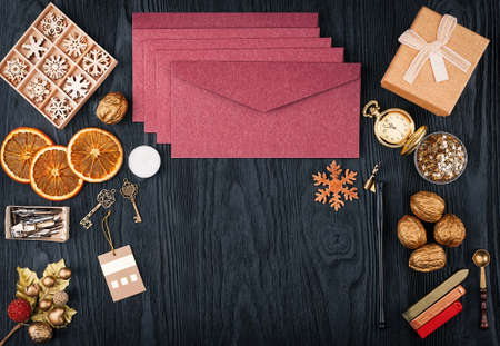 Pack of envelopes, Christmas decorations and postal supplies on a black wooden texture background. Top view with copy spaceの写真素材