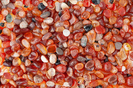 Small rounded red agate stones textured background