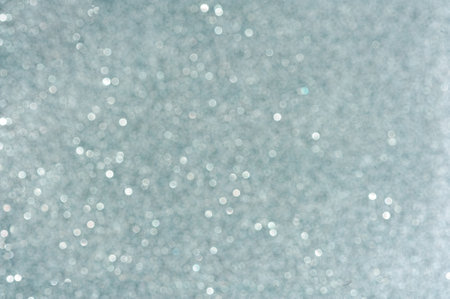 Blue glitter paper blurred background with bokeh closeupの写真素材