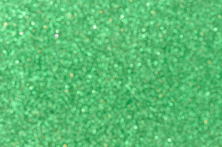 Blurred green color glitter paper background with bokeh closeupの写真素材