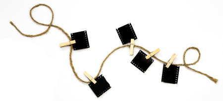 Blank photo frames with hanger on rope lay on white backgroundの写真素材