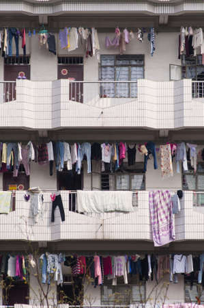Many clothes hanging over balcony at Chinese dormitory, apartment のeditorial素材