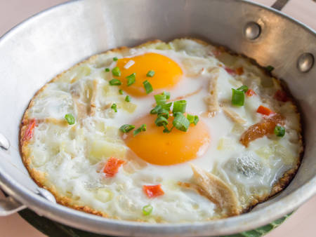 Homemade Thai style fried egg in pan with porkの写真素材