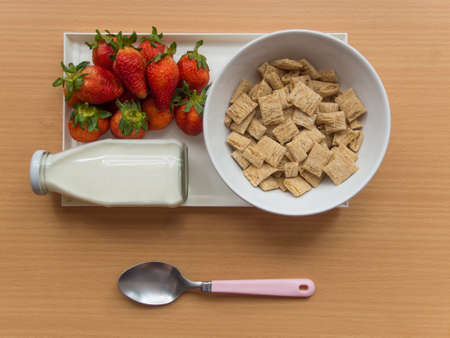 Home cereal and strawberry with bottle of milk, breakfast on wooden tableの写真素材