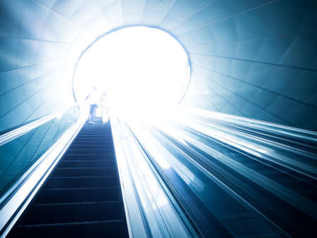 Escalator and light at end of tunnelの写真素材