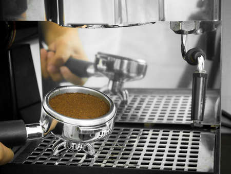 Barista holding portafilter with ground coffeeの写真素材