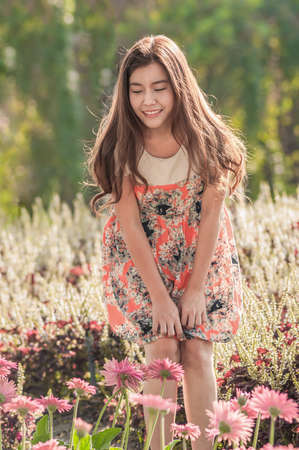 Beautiful Woman With Gerbera Flower Enjoying Nature against Nature Backgroundの写真素材