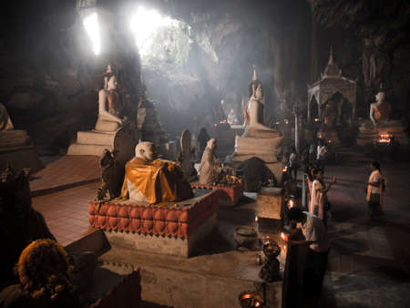 YALA, THAILAND- APRIL 14 : People made a prayer in front of the Buddha in cave of Wat Thum Ku Har Pimuk for Thai new year festival on April, 2014 in Yala, Thailand.のeditorial素材